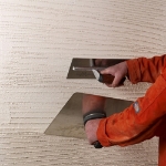 Image of render being applied to a wall with two trowels